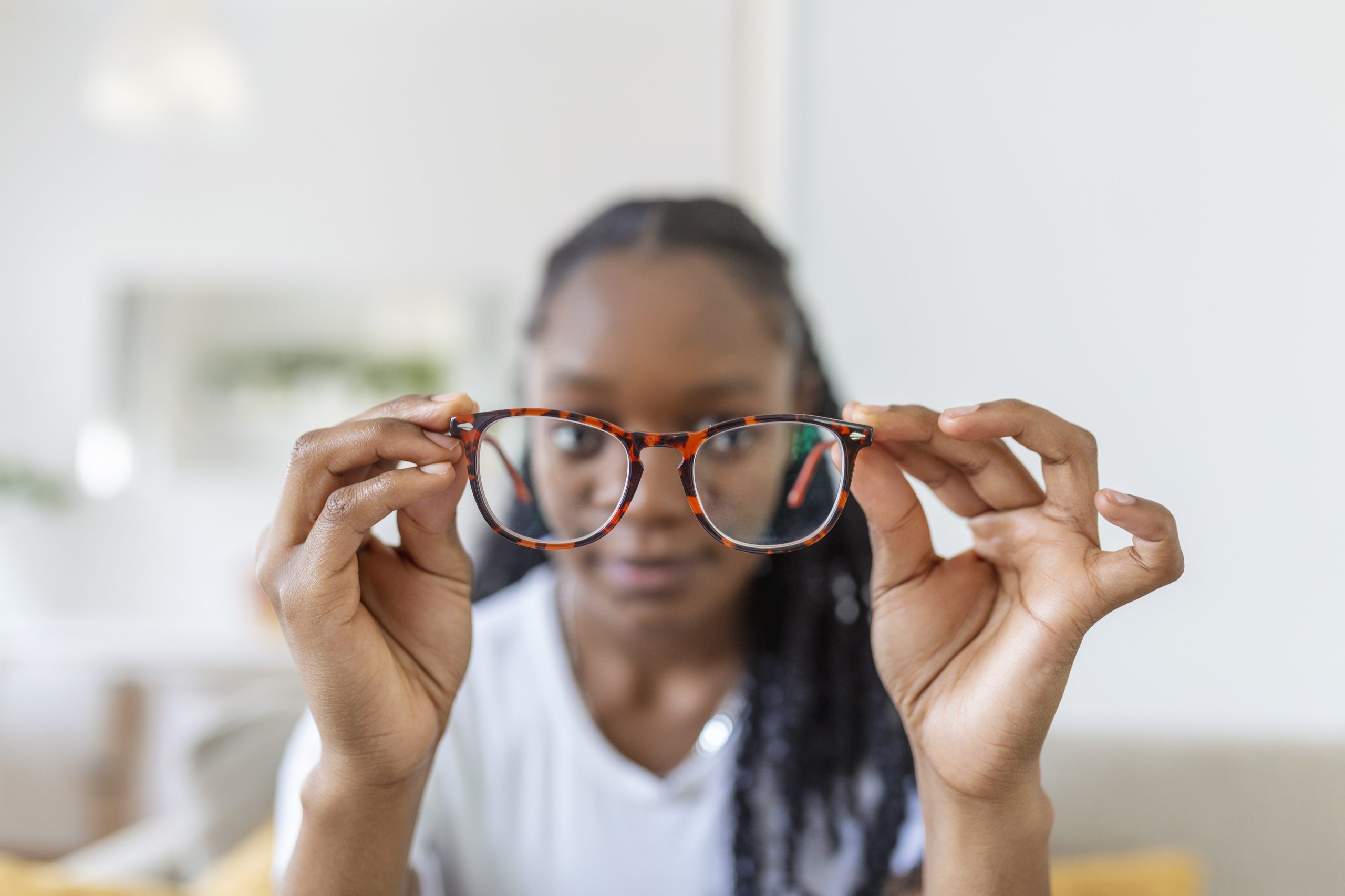 services-01 Young African Woman Holds Glasses With Diopter Lenses Looks Through Them Problem Myopia Vision Correction Scaled